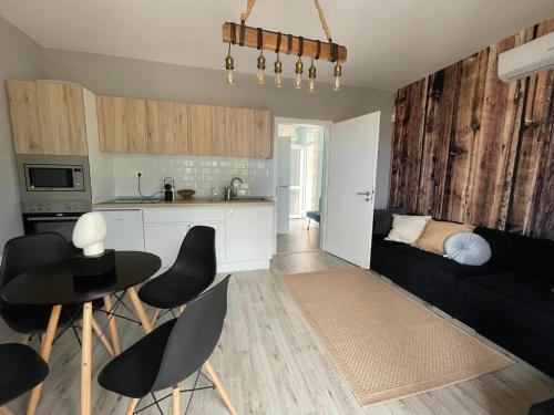 eine Küche und ein Wohnzimmer mit einem Tisch und Stühlen in der Unterkunft Z-HOMES in Zamárdi