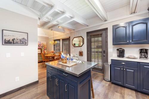 a kitchen with blue cabinets and a kitchen island at Rustic Modern Getaway - Mtn View - Creek - Hammock - Rest in Sevierville