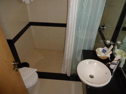 a small bathroom with a toilet and a sink at SP Grand Days in Trivandrum
