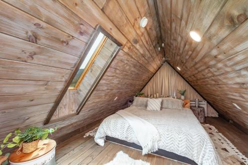 セバービルにあるRomantic A-frame Private HotTub Firepit NearGSMNPの木造家屋内のベッドルーム(ベッド付)
