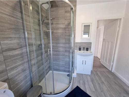 a bathroom with a shower and a sink at Relaxed Double bed with private bathroom, parking, WiFi and garden. in Leeds