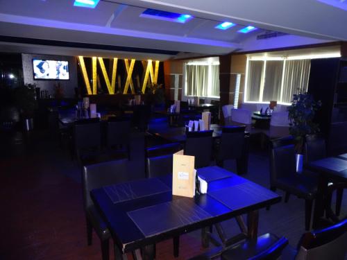 a restaurant with blue tables and chairs and a tv at SP Grand Days in Trivandrum