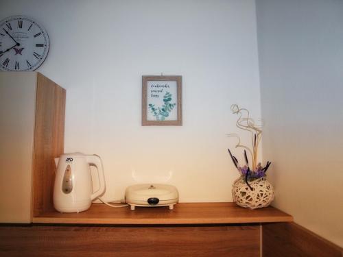 eine Theke mit Kaffeemaschine und eine Uhr an der Wand in der Unterkunft Panoramico Apartment Opatija in Opatija