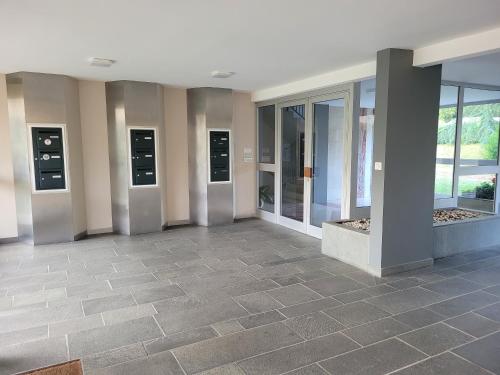 a lobby with glass doors and a tile floor at Studio récent résidence Charles Quint in Gray