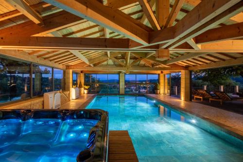 an indoor swimming pool with a wooden ceiling at Domaine de Ravat in Sarlat-la-Canéda