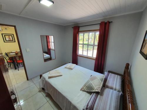 a bedroom with a bed and a window and a mirror at Cabañas Selva Verde in Puerto Iguazú
