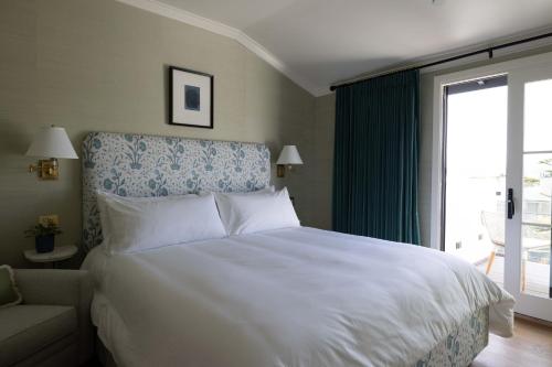 a bedroom with a large white bed and a window at Villa Mara Carmel in Carmel