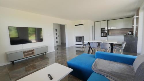 sala de estar con sofá azul y mesa en Apartmánový dom Žiar s vírivkou a saunou en Žiar