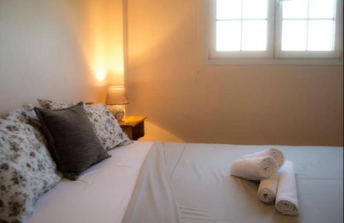 uma cama branca com duas toalhas com uma janela em Villa Mastiha , Komi Beach em Kómi