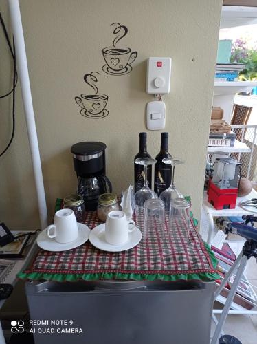 a table with cups and saucers on top at Paraiso Hortensia Ecolodge in Santiago de los Caballeros