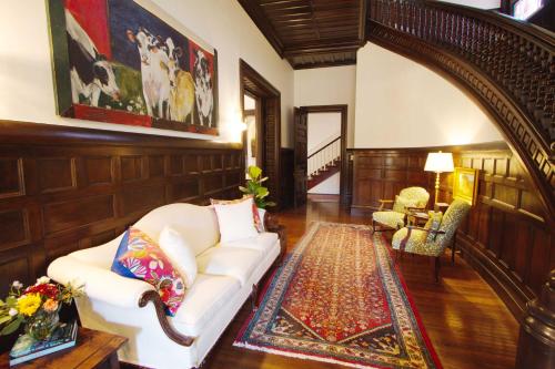 a living room with a white couch and a rug at Louisville Bourbon Inn in Louisville
