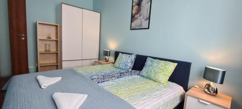 um pequeno quarto com uma cama e um sofá em Apartament Św. Wojciecha em Gdynia