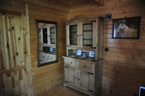 Habitación con paredes de madera y cocina con armarios de madera. en Szyszka i Róża Domek na Jurze, en Zelasko