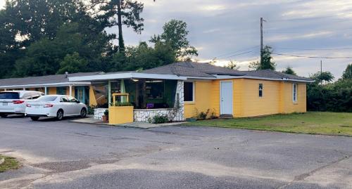 a yellow house with a car parked in front of it at LAMPLIGHTER INN in Childersburg