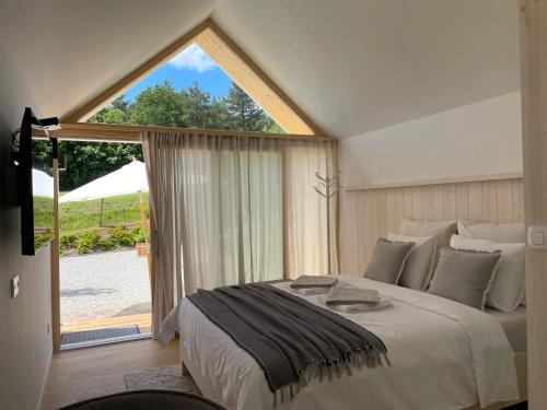 a bedroom with a large bed and a large window at Domačija Pri Momi in Križevci