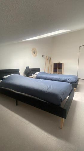 a large bed in a room with blue sheets at Appartement duplex 70m2 avec box privé à 150 m des telecabines in Briançon