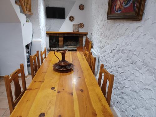 a wooden table in a room with a fireplace at Cal Massana in Sant Guim de la Plana