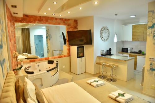 a large bathroom with a tub and a kitchen at Design Apartment PREMIUM SPA LUX 4 STAR "DUBAI" Completely PRIVATE Wellness & Spa FREE INCLUDED Sauna & Jacuzzi & Salt Wall & Fire place & 3D Ceilings & Business WiFi & NETFLIX & Keyless code entry & FULL SMART APP & SECURE 2 Parking place in Ćuprija