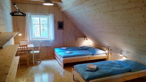 a room with two beds and a table and a dining room at Malá Hofmanka, horská chalupa na samotě, Krkonoše in Vítkovice