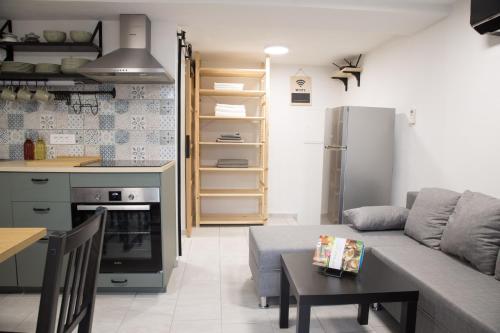 eine Küche und ein Wohnzimmer mit einem Sofa und einem Tisch in der Unterkunft Apartma Licko in Domžale