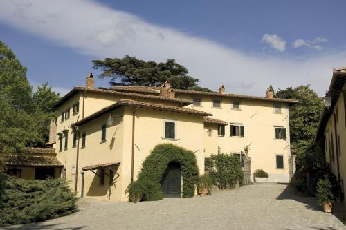 ein großes Gebäude mit einem Bogen davor in der Unterkunft Villa I Ciabattini in Vicchio