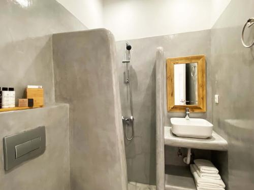 a bathroom with a sink and a shower with a mirror at Lyra Seafront Apartment , Paroikia Town Center in Parikia