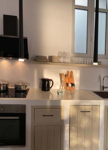 a kitchen with white cabinets and a stove top oven at Lyra Seafront Apartment , Paroikia Town Center in Parikia
