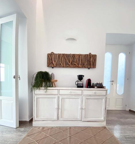 a kitchen with white cabinets and a wall with windows at Lyra Seafront Apartment , Paroikia Town Center in Parikia