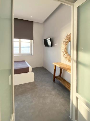 a small bedroom with a bed and a mirror at Lyra Seafront Apartment , Paroikia Town Center in Parikia