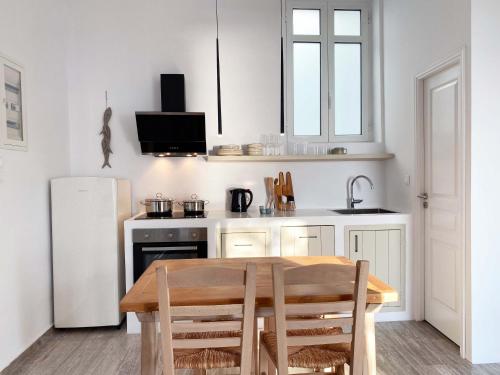 a kitchen with a wooden table and a white refrigerator at Lyra Seafront Apartment , Paroikia Town Center in Parikia