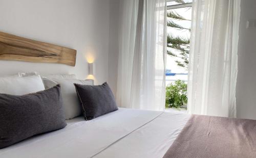 a bedroom with a large white bed with a window at Lyra Seafront Apartment , Paroikia Town Center in Parikia