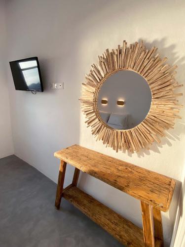 a mirror on a wall next to a wooden bench at Lyra Seafront Apartment , Paroikia Town Center in Parikia