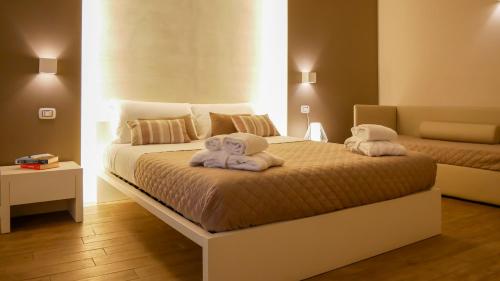 1 dormitorio con 2 camas y toallas. en La Banchina Holiday Rooms, en Trani