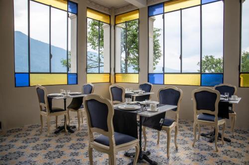 a dining room with tables and chairs and windows at Ca Meison in Cannobio