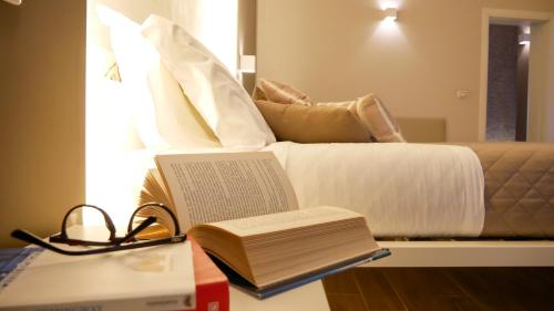a bed with books and a laptop on a table at La Banchina Holiday Rooms in Trani