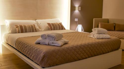 a bedroom with a bed with towels on it at La Banchina Holiday Rooms in Trani