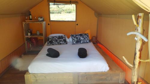 Bett in einem kleinen Zimmer in einem Zelt in der Unterkunft LOVE HORIZON in Monprimblanc