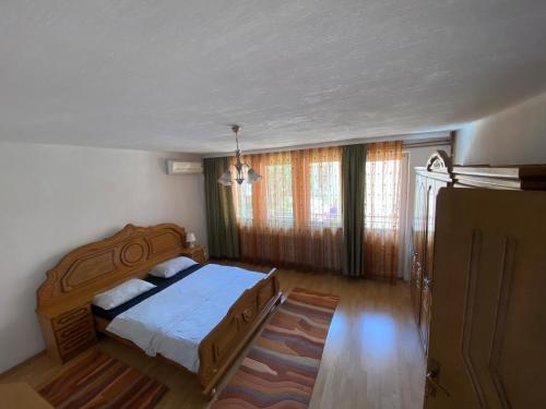 a bedroom with a bed and a large window at Cima Apartment in Pristina