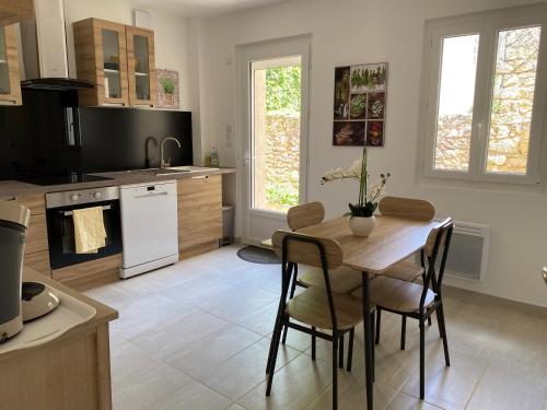 une cuisine avec une table et des chaises dans une pièce dans l'établissement A Mouleydier chez Romane, à Mouleydier