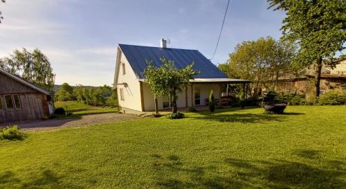 a small white house with a blue roof at Chmarnik in Polańczyk