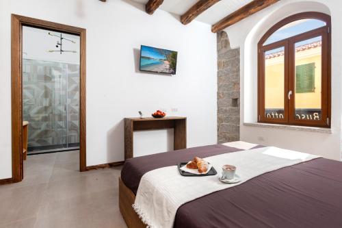 a bedroom with a bed with a tray of food on it at Il Busciolotto in Santa Teresa Gallura