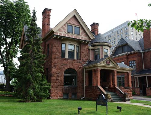 a red brick house with a tree in the yard at The Inn on Ferry Street in Detroit