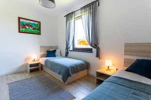 1 Schlafzimmer mit 2 Betten und einem Fenster in der Unterkunft Apartamenty - Dom Smołdziński Las in Smołdziński Las