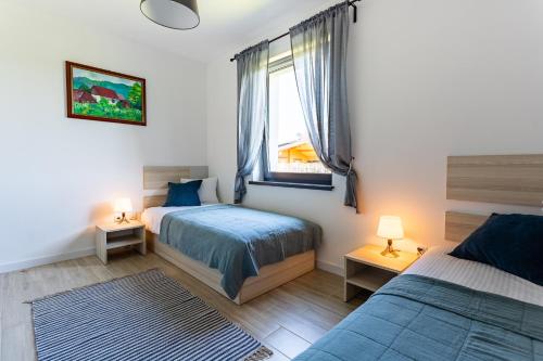 sypialnia z dwoma łóżkami i oknem w obiekcie Apartamenty - Dom Smołdziński Las w Smołdzińskim Lesie
