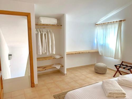 a bedroom with a mirror and a bed in a room at Es Cucó in Cala Galdana