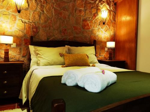 a bedroom with a bed with two towels on it at Quinta do Vale Encantado "the Valley" - Santarém - Portugal in Calhariz