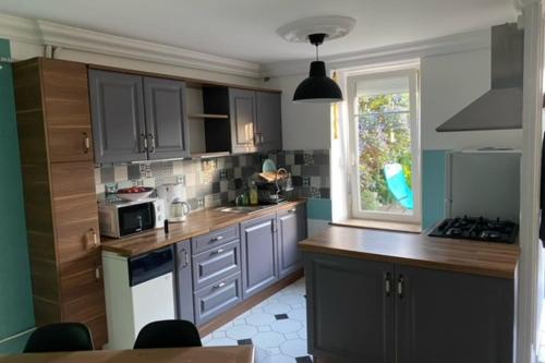 una cocina con armarios grises y una ventana en Nice House With Garden In Arradon, en Arradon