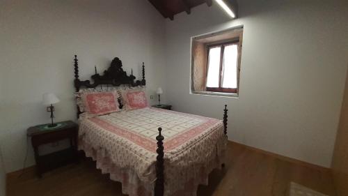 a bedroom with a bed with pink pillows and a window at Casa de Santa Luzia in Vila Praia de Âncora