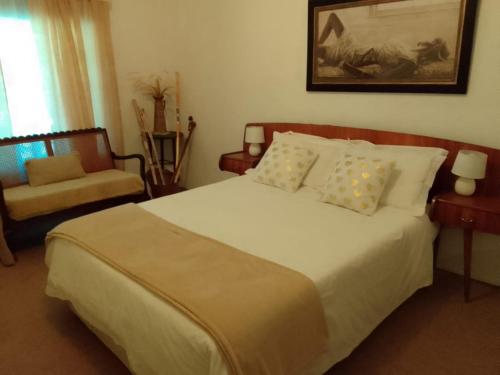 a bedroom with a large white bed and a chair at Thys'e Kombuis & Guest Farm in Kamieskroon