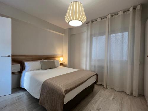1 dormitorio con cama y ventana grande en Apto con vistas a BAHÍA DE PASAJES, a 10 min del centro de San Sebastián, en Lezo
